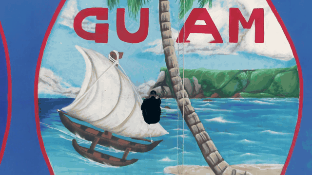 Aerial view of a basketball court painted with a Guam seal mural
